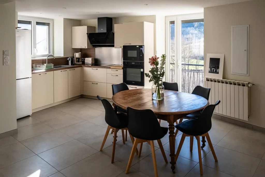 Coin repas de la cuisine ouvert sur le balcon