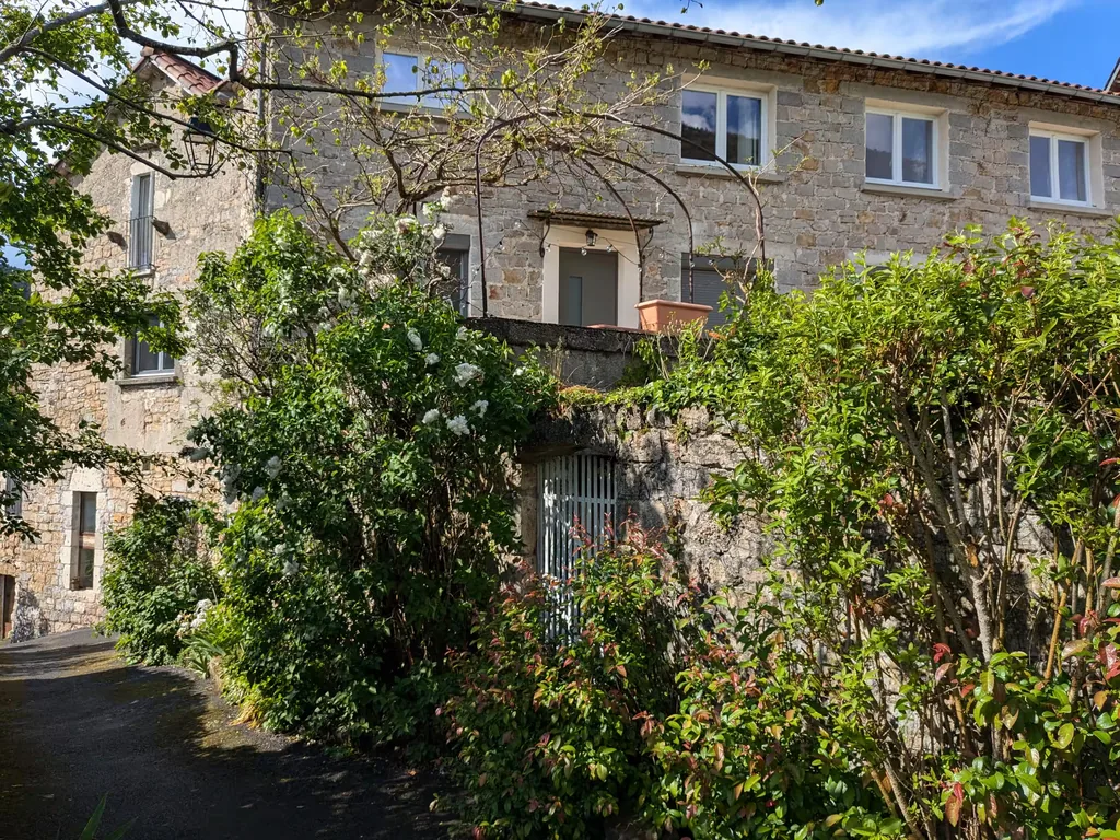 Maison en pierre entourée de végétation du gîte Au bord du Tarn