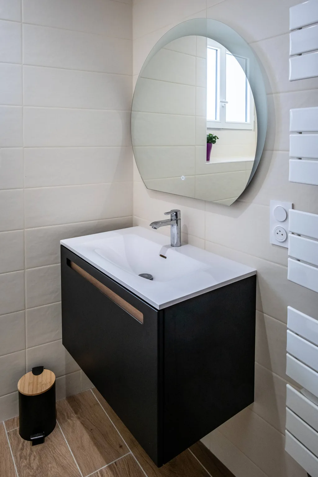 Salle de bain avec vasque et miroir rond du gîte Au bord du Tarn