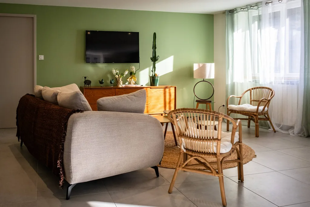 Séjour avec canapés et fauteuils en rotin du gîte Au bord du Tarn