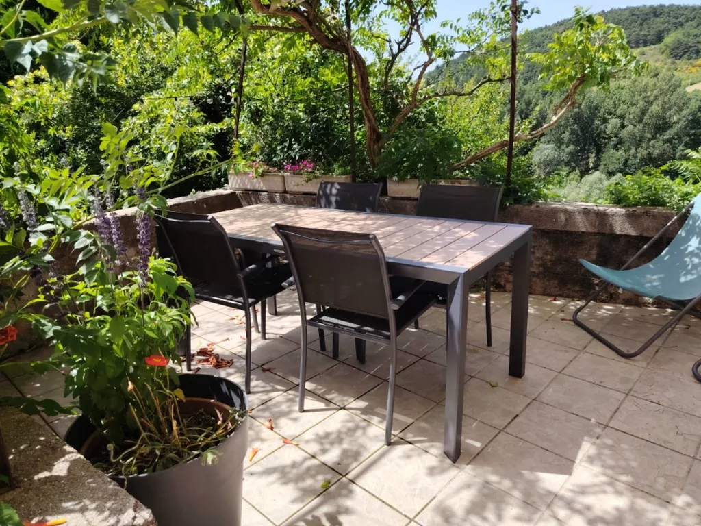 Terrasse repas et transat entourés de verdure