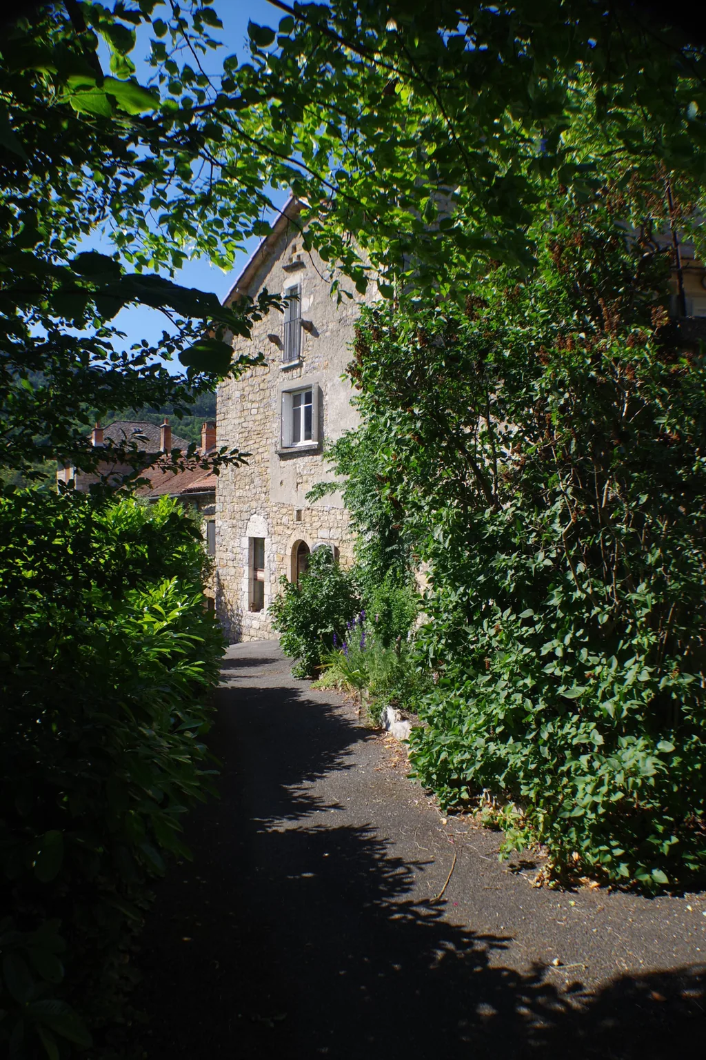 Façade en pierre et chemin d'accès du gîte Le Pailler d'Étienne