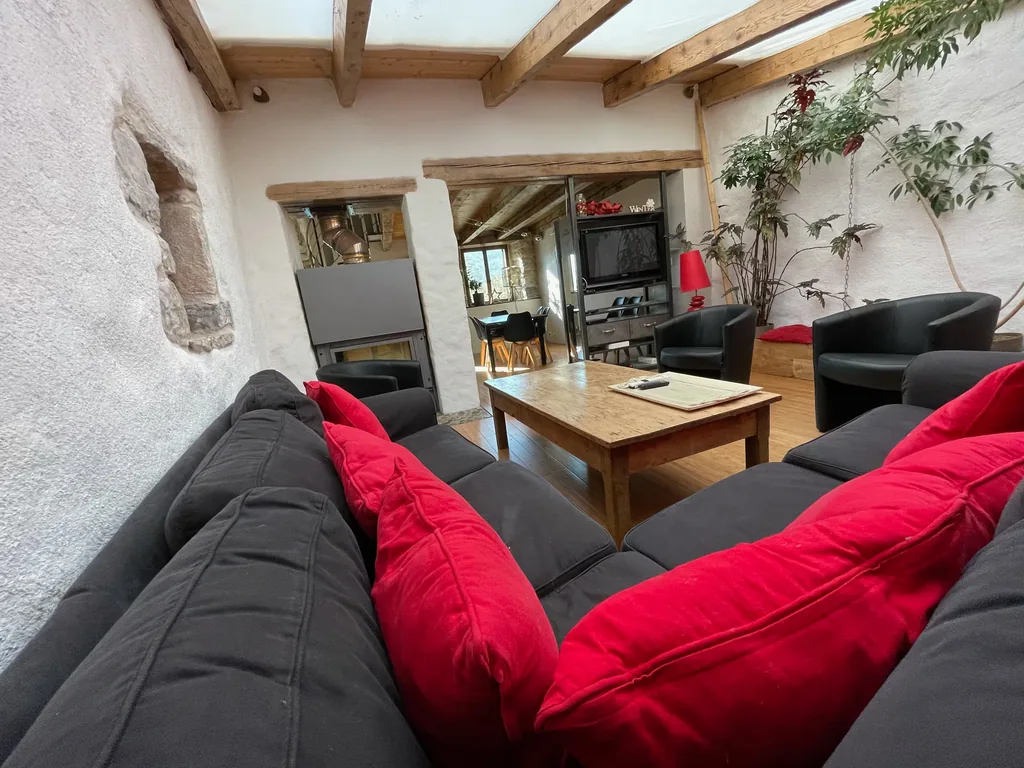 Salon avec canapés et coussins rouges du gîte près de Millau