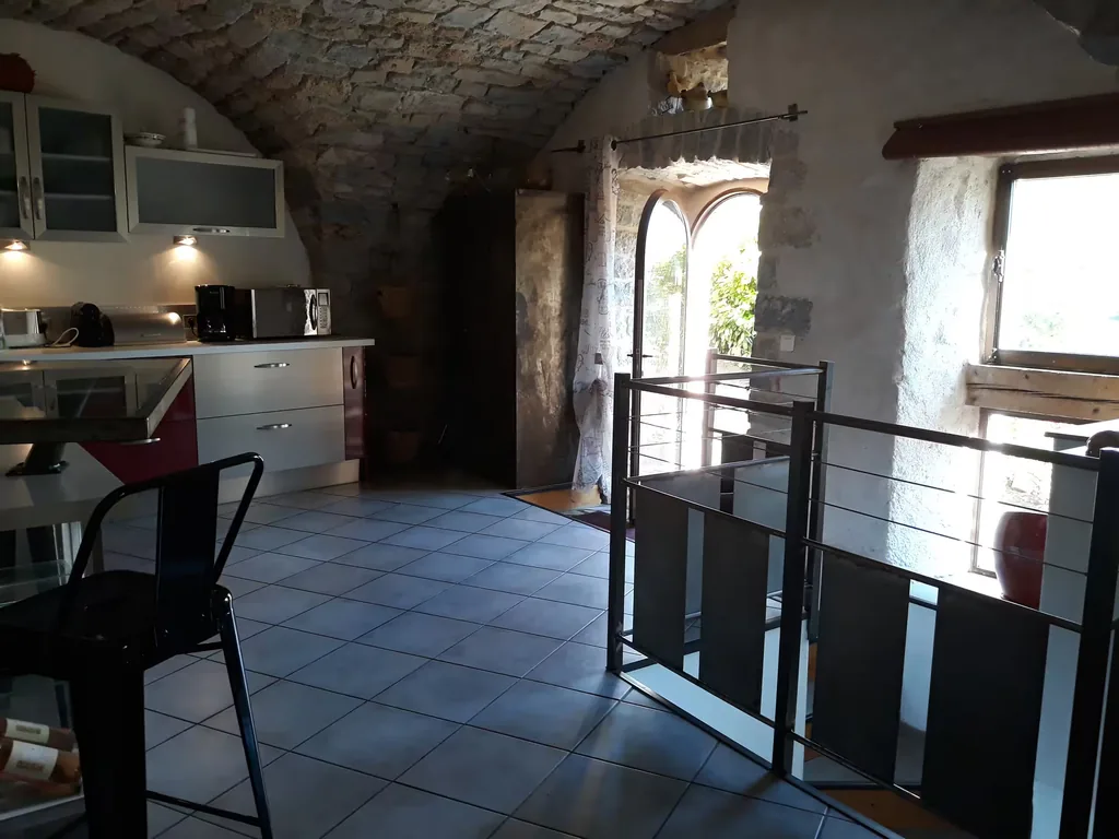 Séjour sous voûte de pierre ouvert sur la cuisine du gîte spa