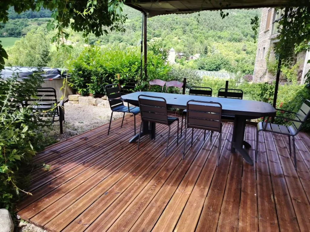 Grande terrasse en bois sous pergola du gîte Le Pailler d'Étienne