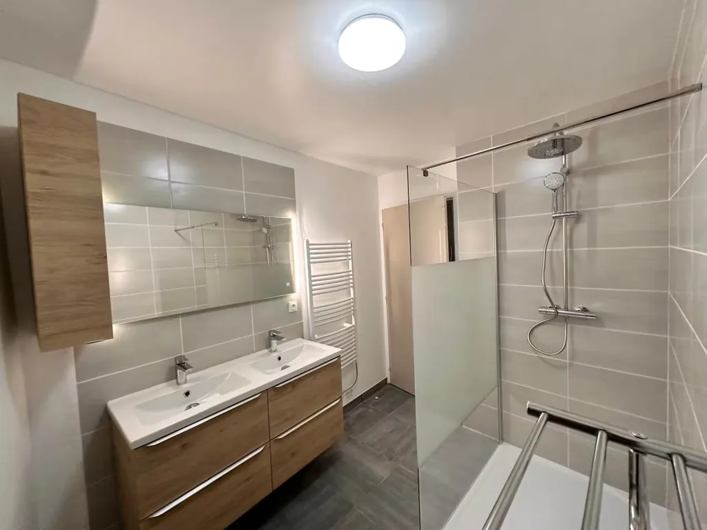 Salle de bain rénovée avec douche et double vasque