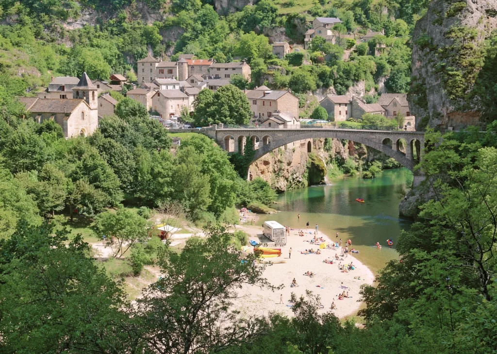 Village au bord du Tarn, son pont de pierre et sa plage de rivière dans les Gorges du Tarn