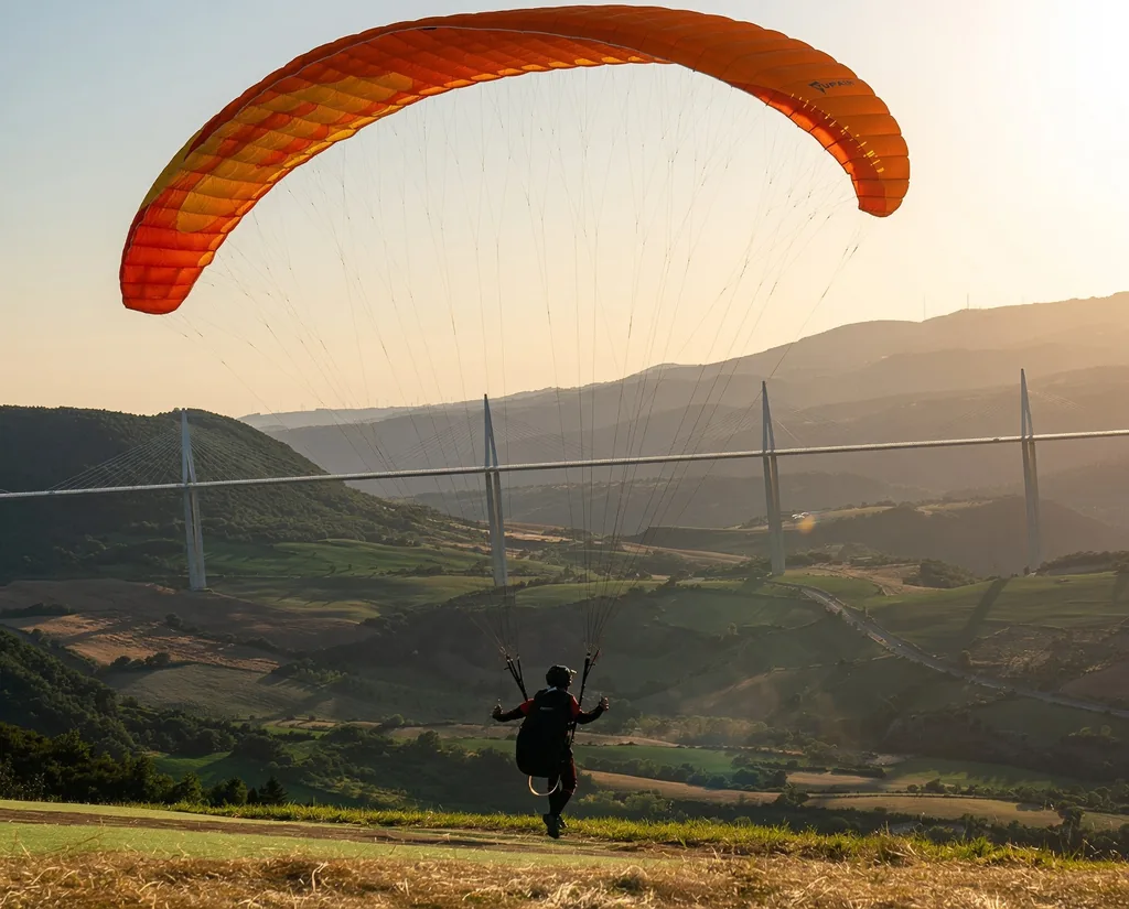 Parapente au coucher du soleil face au Viaduc de Millau